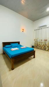 a bedroom with a blue bed in a room at Elisha Place Hiriketiya in Dickwella +144 photos