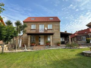 a large brick house with a red roof at Casa de Romaxe in Muros