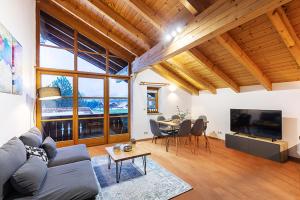 雷特温克尔MyWinkl Design-Ferienwohnungen的客厅里有一张沙发、一张桌子和几把椅子