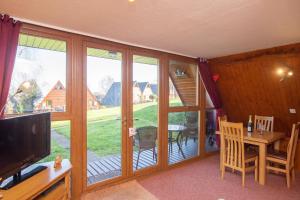 a living room with a sliding glass door with a table at Chalet 134 in Deal