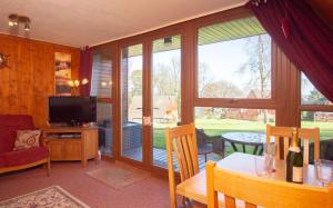a living room with a television and a table with chairs at Chalet 134 in Deal