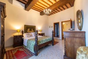 a bedroom with a bed and a dresser in a room at Castello di Sovicille - Residenza d'Epoca in Sovicille