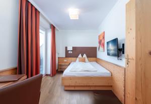 a hotel room with a bed and a desk at Hotel Schönberger in Nussdorf am Attersee