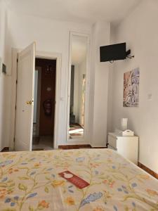 a bedroom with a bed and a flat screen tv at Hotel Betania in Benalmádena