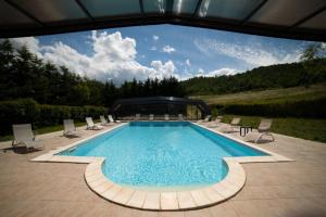 uma grande piscina com cadeiras e avisor em La Foresteria di San Leo em Trivigno