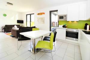 een keuken en een woonkamer met een tafel en stoelen bij Fewo Leuchtfeuer 6_RODI in Peenemünde