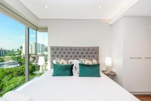 a bedroom with a white bed with a large window at Park Central Residence - Building with Generator in Johannesburg +282 photos