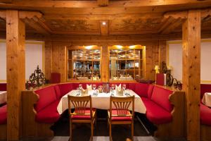 a dining room with a table and red chairs at IFA Alpenhof Wildental Hotel Kleinwalsertal Adults only in Mittelberg