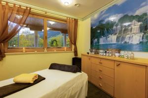 Schlafzimmer mit einem Bett und einem Fenster in der Unterkunft IFA Alpenhof Wildental Hotel Kleinwalsertal Adults only in Mittelberg
