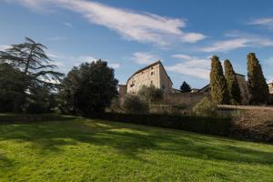 un edificio en medio de un campo verde en Castello di Sovicille - Residenza d'Epoca, en Sovicille