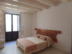 Schlafzimmer mit einem Bett und einem Fenster in der Unterkunft Allegrakori in Syrakus