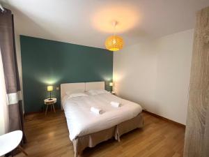 una camera con un letto bianco e una parete verde di Le Havre Citadin - Maison de ville à Poitiers a Poitiers