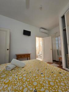 a bedroom with a large bed with a yellow blanket at Hotel Betania in Benalmádena