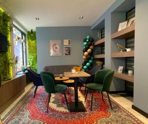 a dining room with a table and green chairs at Kristall Apartments Premium in Šabac