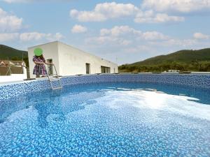 una persona in piedi su una scala accanto a una piscina di Casa Rural Espadan Suites ad Artana
