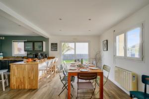 a kitchen and dining room with a table and chairs at Maison avec piscine pour 8 - 500m de la plage in Plobannalec-Lesconil
