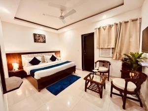 um quarto de hotel com uma cama e uma cadeira em The Pacific Grand Haridwar em Haridwar