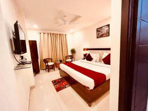 a hotel room with a bed and a television at The Pacific Grand Haridwar in Haridwār