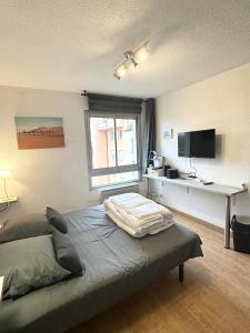 a bedroom with a bed and a desk and a television at Studio Paisible Cœur de Paray-Le-Monial app 303 in Paray-le-Monial