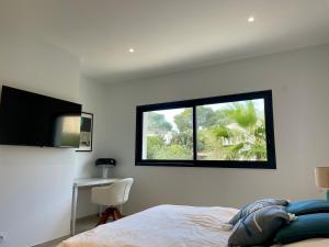 Schlafzimmer mit einem Bett, einem Fenster und einem Schreibtisch in der Unterkunft Villa 443 in Saint-Raphaël