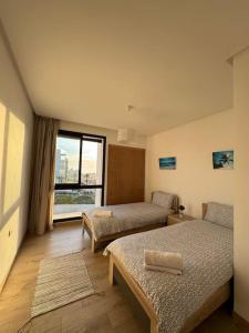 a hotel room with two beds and a window at Superbe appartement vue sur mer in Sale