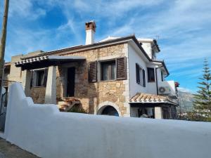 a house with a white fence in front of it at Casa Oliena in Oliena