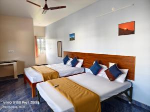 a hotel room with two beds and a tv at RPM home stay in Tiruvannāmalai