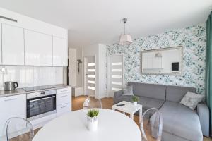 グディニャにあるLTC Apartments Ujejskiegoのソファとテーブルのあるキッチンとリビングルーム