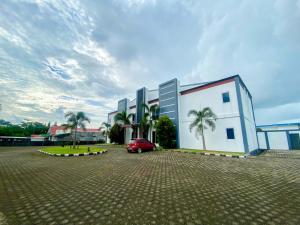 a red car parked in front of a building at RedDoorz @ Wisma Graha Andi Djemma in Manda