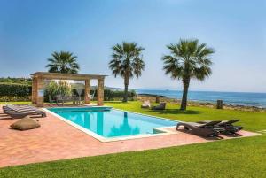 una piscina con cenador y palmeras en Villa Alegria Kefalonia en Argostoli