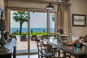 comedor con mesa y vistas al océano en Villa Alegria Kefalonia en Argostoli