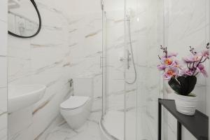 a white bathroom with a toilet and a sink at Royal Castle View Warsaw by Renters in Warszawa
