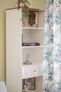 a bedroom with a white book shelf with tropical wallpaper at Royal Castle View Warsaw by Renters in Warszawa