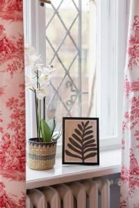 a window sill with two picture frames and a plant at Royal Castle View Warsaw by Renters in Warszawa