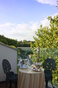 stół z 2 krzesłami i stół z kieliszkami do wina w obiekcie Hotel de la Ville Monza - Small Luxury Hotels of the World w mieście Monza