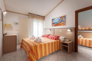ein Hotelzimmer mit 2 Betten und einem Spiegel in der Unterkunft Hotel Atlantic in Gatteo a Mare