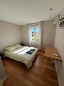 - une chambre avec un lit, une table et une fenêtre dans l'établissement Villa sur la Côte d’Azur avec piscine, à La Colle-sur-Loup