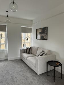 - un salon blanc avec un canapé et une table dans l'établissement 2 Kingsmead Square, à Bath