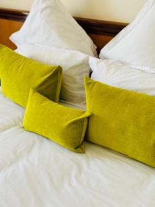 a group of yellow pillows on a bed at Hotel Idou Tiznit in Tiznit