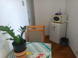 um pequeno quarto com uma mesa e um micro-ondas em Suíte no centro de Belo Horizonte em Belo Horizonte
