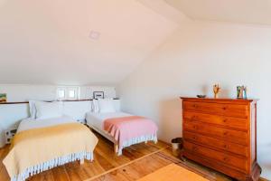 a bedroom with two beds and a dresser at Casalinho de Bicesse in Alcabideche