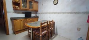 een keuken met een tafel en stoelen en een klok bij Casa Mar, with parking and ideal for families in Sant Feliu de Guixols