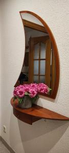 聖費柳德吉克索爾斯的住宿－Casa Mar, with parking and ideal for families，墙上的镜子,架子上是粉红色的花
