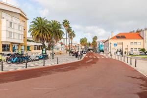 a street in a city with palm trees and buildings at Cascais Beach House in Cascais