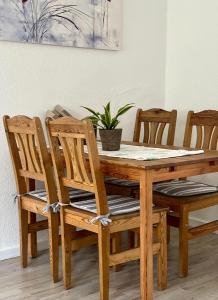 ein Holztisch und Stühle mit einer Pflanze darauf in der Unterkunft Zimmer in Werneuchen bei Berlin in Werneuchen