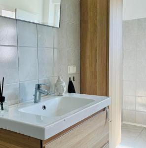 ein weißes Waschbecken in einem Badezimmer mit einem Spiegel in der Unterkunft Zimmer in Werneuchen bei Berlin in Werneuchen