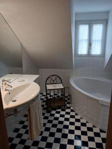a white bathroom with a tub and a sink at Gästehaus Hans Moser in Purbach am Neusiedlersee