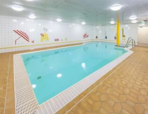 duży basen z niebieską wodą w budynku w obiekcie IFA Breitach Apartments Kleinwalsertal w mieście Mittelberg