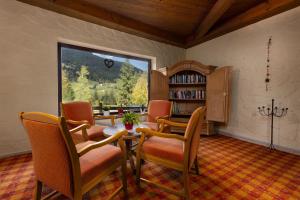 d'une salle à manger avec une table, des chaises et une fenêtre. dans l'établissement IFA Breitach Apartments Kleinwalsertal, à Mittelberg