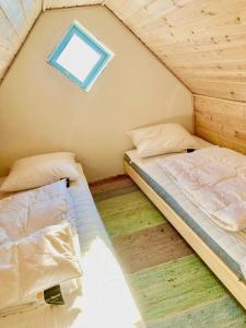 2 camas en una habitación pequeña con ventana en Mormors Gårdhus ved stranden, en Rude